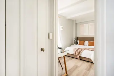 a white bedroom with a bed and a desk at 73-508 New 1BR 1Bth UWS Doorman Gym in New York