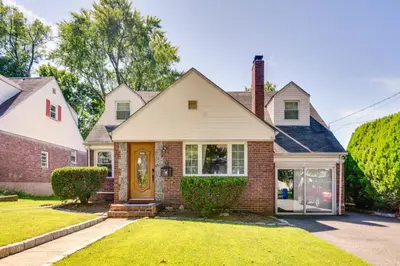 a home with a brick house with a yellow door at 4 Mi to NYC, Shared Yard Englewood Apartment! in Englewood