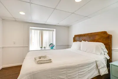 a bedroom with a large bed with white sheets and a window at Shared Yard, 4 Mi to NYC Englewood Apartment! in Englewood