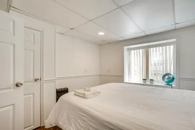 a white bedroom with a bed and a window at Shared Yard, 4 Mi to NYC Englewood Apartment! in Englewood