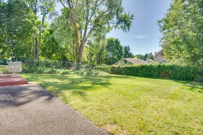 a yard with a fence and a chair in the grass at Shared Yard, 4 Mi to NYC Englewood Apartment! in Englewood