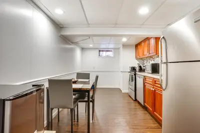 a kitchen with a table and a refrigerator at Shared Yard, 4 Mi to NYC Englewood Apartment! in Englewood