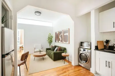 a living room with a couch and a washing machine at 444-1A Beautiful 1BR Midtown West in New York