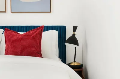 a bedroom with a bed with a red pillow and a lamp at 444-1A Beautiful 1BR Midtown West in New York