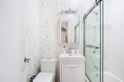 a bathroom with a toilet and a sink and a shower at 444-1A Beautiful 1BR Midtown West in New York