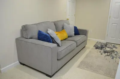 a gray couch with pillows on it in a living room at Spacious 2BD near Princeton, Cafes! Family, Backyard, Parking