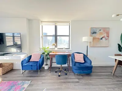 a living room with a table and two blue chairs at Luxury 2BR - Elevator-Gym-Laundry-10 Min to NYC in Hoboken