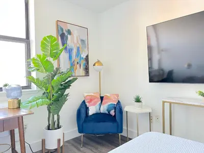 a blue chair in a bedroom with a plant at Luxury 2BR - Elevator-Gym-Laundry-10 Min to NYC in Hoboken