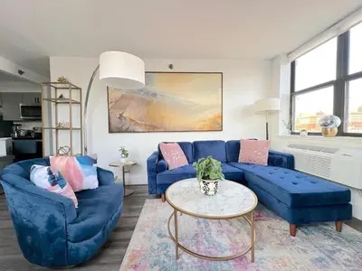 a living room with blue couches and a table at Luxury 2BR - Elevator-Gym-Laundry-10 Min to NYC in Hoboken