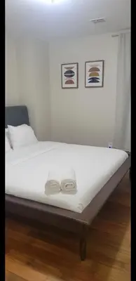 a bed with two towels sitting on top of it at Exquisite 4 Beds Near EWR NYC in East Orange