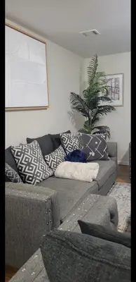 a living room with a couch with pillows on it at Exquisite 4 Beds Near EWR NYC in East Orange