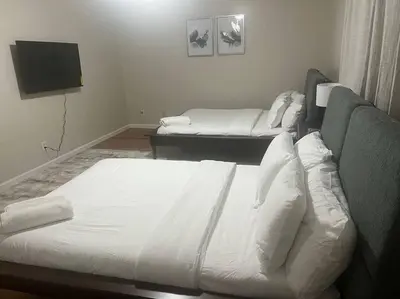 a bedroom with two beds and a flat screen tv at Exquisite 4 Beds Near EWR NYC in East Orange