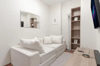 a white living room with a white couch and a tv at Chic 3Bd 1Bth Near Empire State in New York
