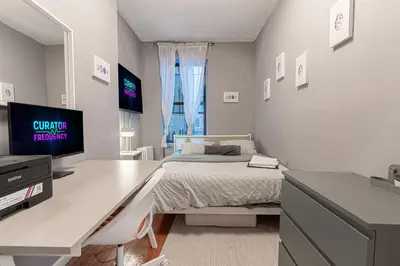a bedroom with a desk with a bed and a tv at Chic 3Bd 1Bth Near Empire State in New York
