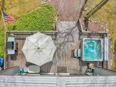 an overhead view of a pool and an umbrella at Pet Friendly! Lakefront w Hot Tub, Firepit! in Tobyhanna