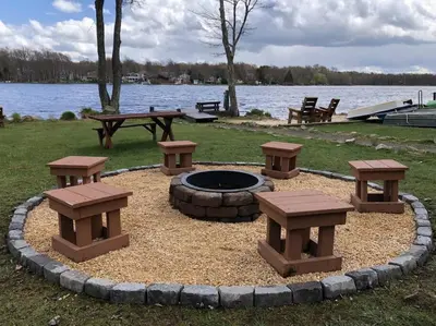 a fire pit with benches and a picnic table at Pet Friendly! Lakefront w Hot Tub, Firepit! in Tobyhanna