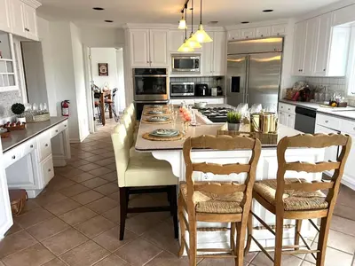 a kitchen with a kitchen island with chairs and a table at THE VILLA Farm Sleeps 20 more in Montgomery