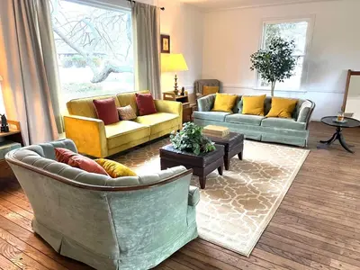 a living room with two couches and a table at THE VILLA Farm Sleeps 20 more in Montgomery