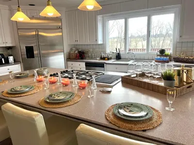 a kitchen with a table with plates and glasses on it at THE VILLA Farm Sleeps 20 more in Montgomery