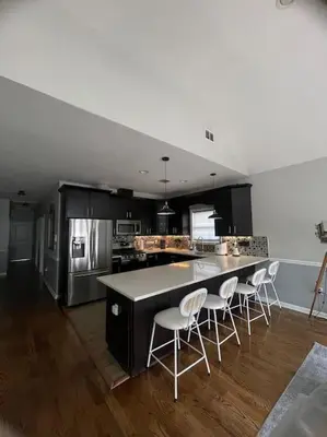 a kitchen with a large island with white chairs at Modern minimalistic 3 bdr Apt Townhouse in Jersey City