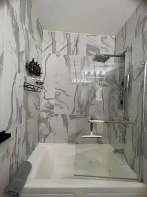 a bathroom with a white tub and a sink at Modern minimalistic 3 bdr Apt Townhouse in Jersey City