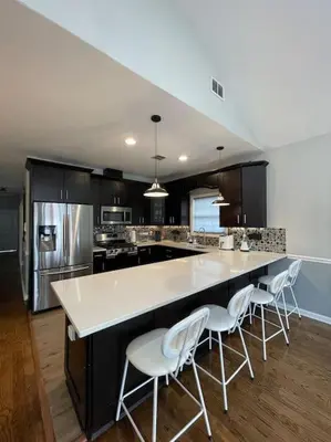 a kitchen with a large white counter and white chairs at Modern minimalistic 3 bdr Apt Townhouse in Jersey City