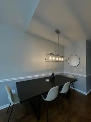 a dining room with a black table and white chairs at Modern minimalistic 3 bdr Apt Townhouse in Jersey City