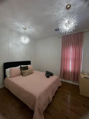a bedroom with a bed and two chandeliers at Modern minimalistic 3 bdr Apt Townhouse in Jersey City