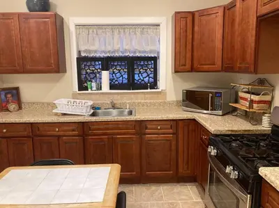 a kitchen with wooden cabinets and a sink and a window at Black Oak Rest in Philadelphia