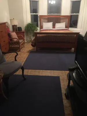 a bedroom with a bed and a chair and a rug at Black Oak Rest in Philadelphia
