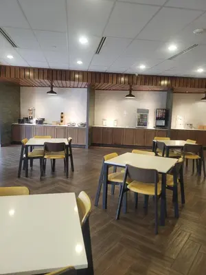 a dining room with tables and chairs and a kitchen at Fairfield Inn & Suites by Marriott in Breinigsville
