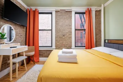 a bedroom with a yellow bed and a desk at 2 Bedroom Home Unit In Lower Manhattan in New York