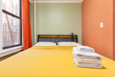 a bedroom with a bed with towels on it at 2 Bedroom Home Unit In Lower Manhattan in New York