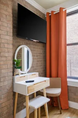 a bathroom with a vanity and a mirror and orange curtains at 2 Bedroom Home Unit In Lower Manhattan in New York