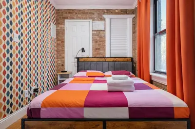 a bedroom with a bed with a colorful blanket at 2 Bedroom Home Unit In Lower Manhattan in New York