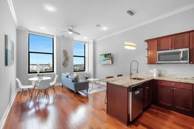 a kitchen and living room with a table and chairs at Modern 1BR with Rooftop Pool & Gym in Philadelphia