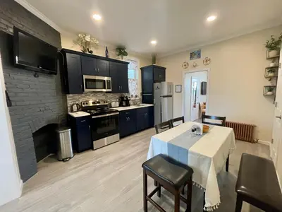 a kitchen with a table and a kitchen with black cabinets at New York City Private Bedroom Near Free Ferry Boat! in Stapleton