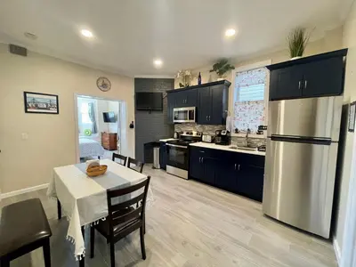 a kitchen with a table and a stainless steel refrigerator at New York City Private Bedroom Near Free Ferry Boat! in Stapleton