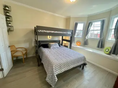 a bedroom with a bunk bed and two windows at New York City Private Bedroom Near Free Ferry Boat! in Stapleton