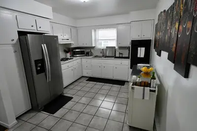 a kitchen with white cabinets and stainless steel appliances at Bright & cozy 2nd Floor Apartment Close to NYC in Bloomfield
