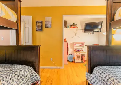 a bedroom with two beds and a tv on the wall at Charming Lakefront Getaway with Hot Tub & Game Room Perfect for Families! in East Stroudsburg
