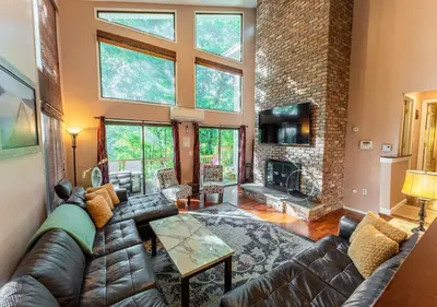 a living room with a couch and a fireplace at Charming Lakefront Getaway with Hot Tub & Game Room Perfect for Families! in East Stroudsburg