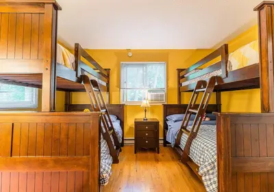 two bunk beds in a room with yellow walls at Charming Lakefront Getaway with Hot Tub & Game Room Perfect for Families! in East Stroudsburg