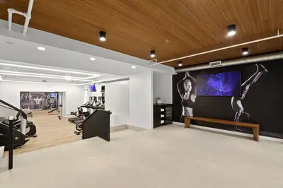 a gym with a large screen on the wall at Blueground Chelsea gym doorman nr market NYC-494 in New York