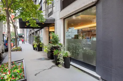 a row of potted plants in front of a store at Blueground Chelsea gym doorman nr market NYC-494 in New York