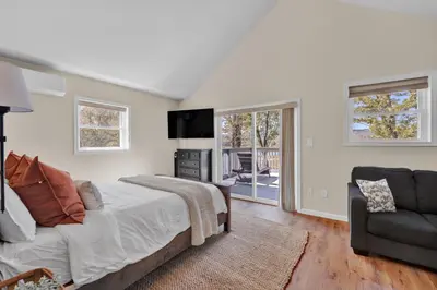 a bedroom with a bed and a couch and a chair at Lakefront, Hot Tub, Dock, Kayaks, Amazing Views in Lake Ariel
