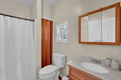 a bathroom with a toilet and a sink and a mirror at Lakefront, Hot Tub, Dock, Kayaks, Amazing Views in Lake Ariel