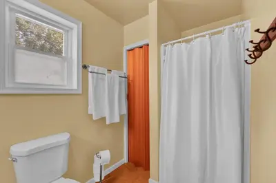 a bathroom with a toilet and a window and a shower at Lakefront, Hot Tub, Dock, Kayaks, Amazing Views in Lake Ariel