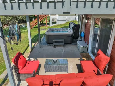 a screened in patio with a couch and a tub at Lakefront, Hot Tub, Dock, Kayaks, Amazing Views in Lake Ariel