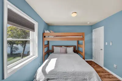 a bedroom with a bed and two windows at Lakefront, Hot Tub, Dock, Kayaks, Amazing Views in Lake Ariel